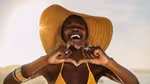 Woman making a heart sign with their hands and smiling