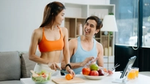 Couple in sportswear preparing healthy meal in kitchen.